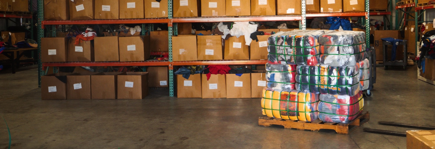 Maison De L'Heritage warehouse — sorted vintage clothing bundles